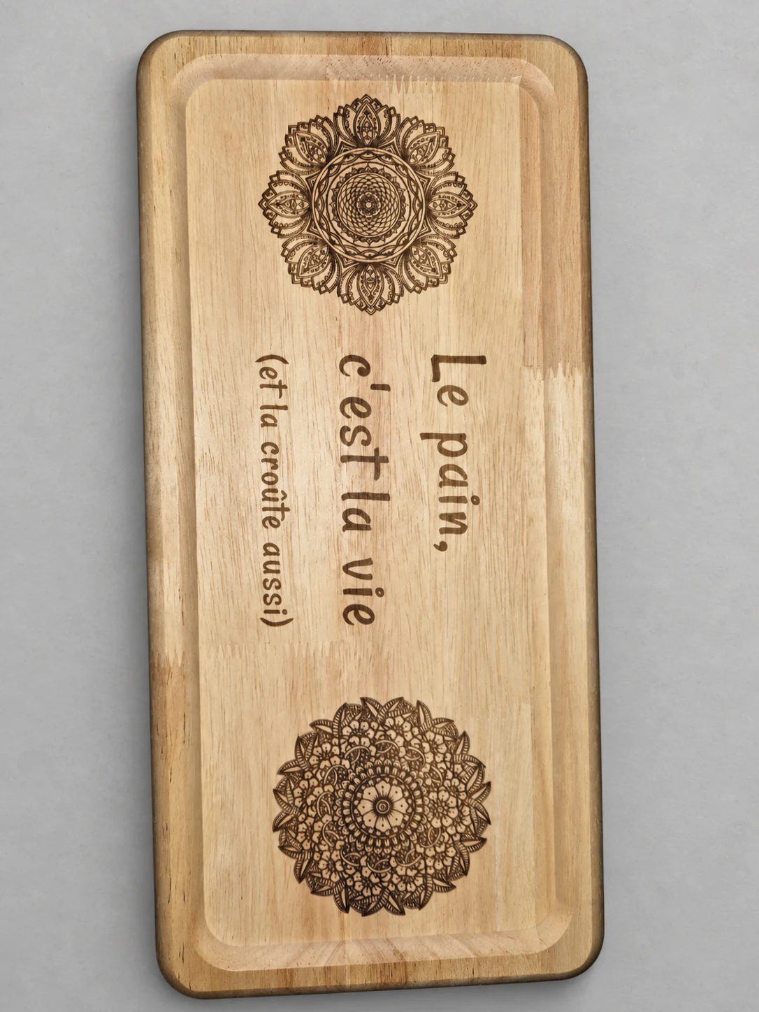 Planche à pain gravée de mandalas et du texte « Le pain, c’est la vie (et la croûte aussi) »